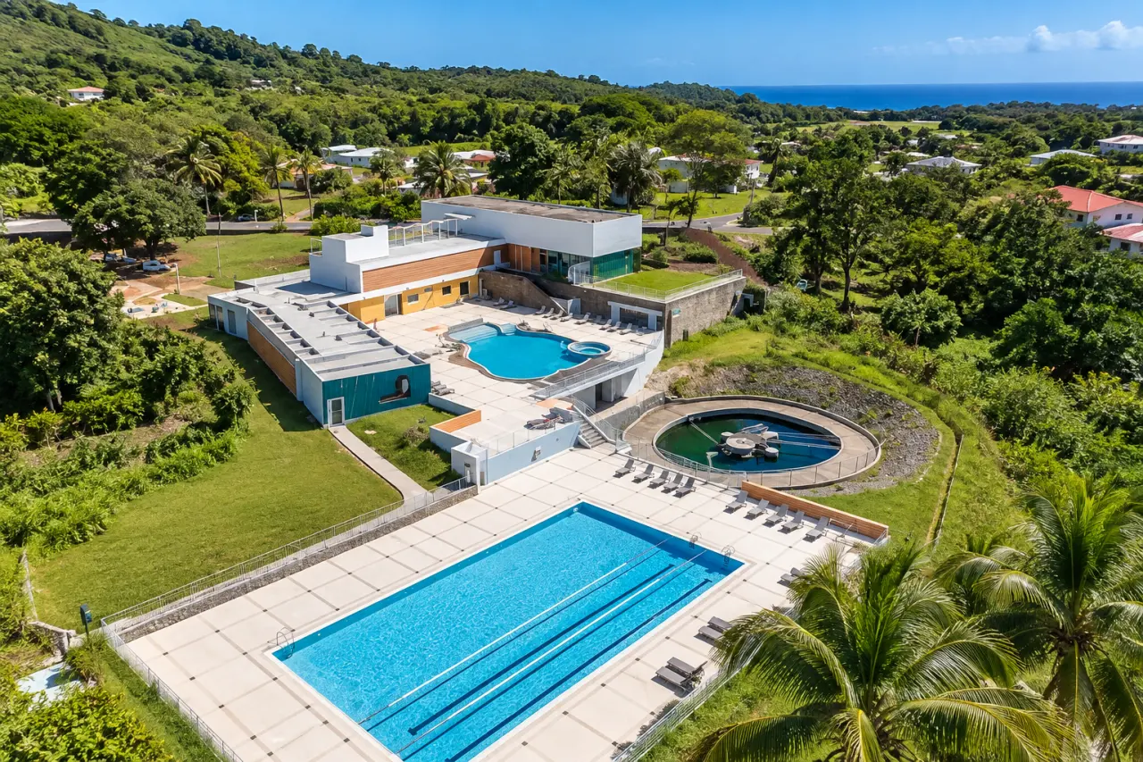 Centre aquatique en Guadeloupe vu du ciel, piscines extérieures, bassin sportif et végétation tropicale.
