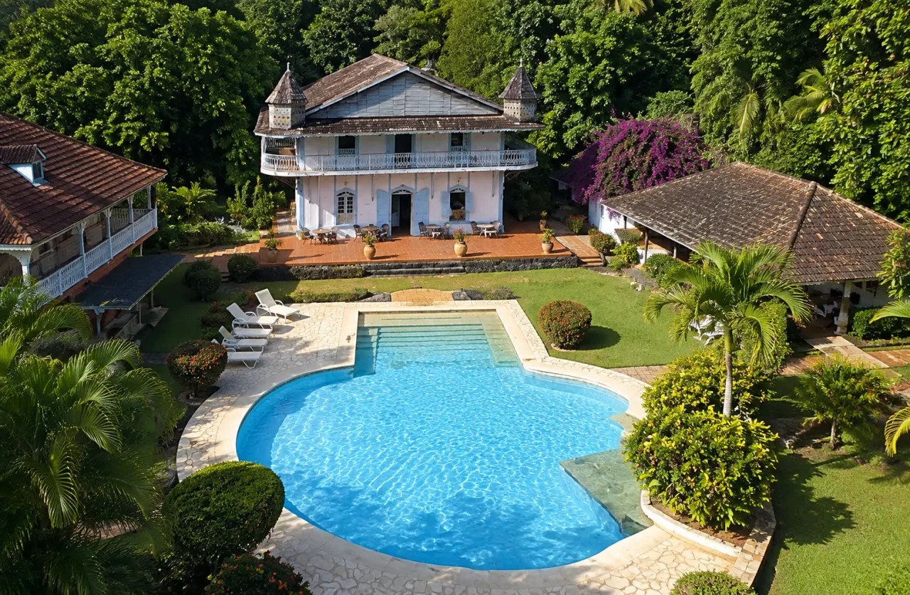 Habitation créole en Martinique vue du ciel, avec maison traditionnelle, piscine, jardins tropicaux et végétation luxuriante.