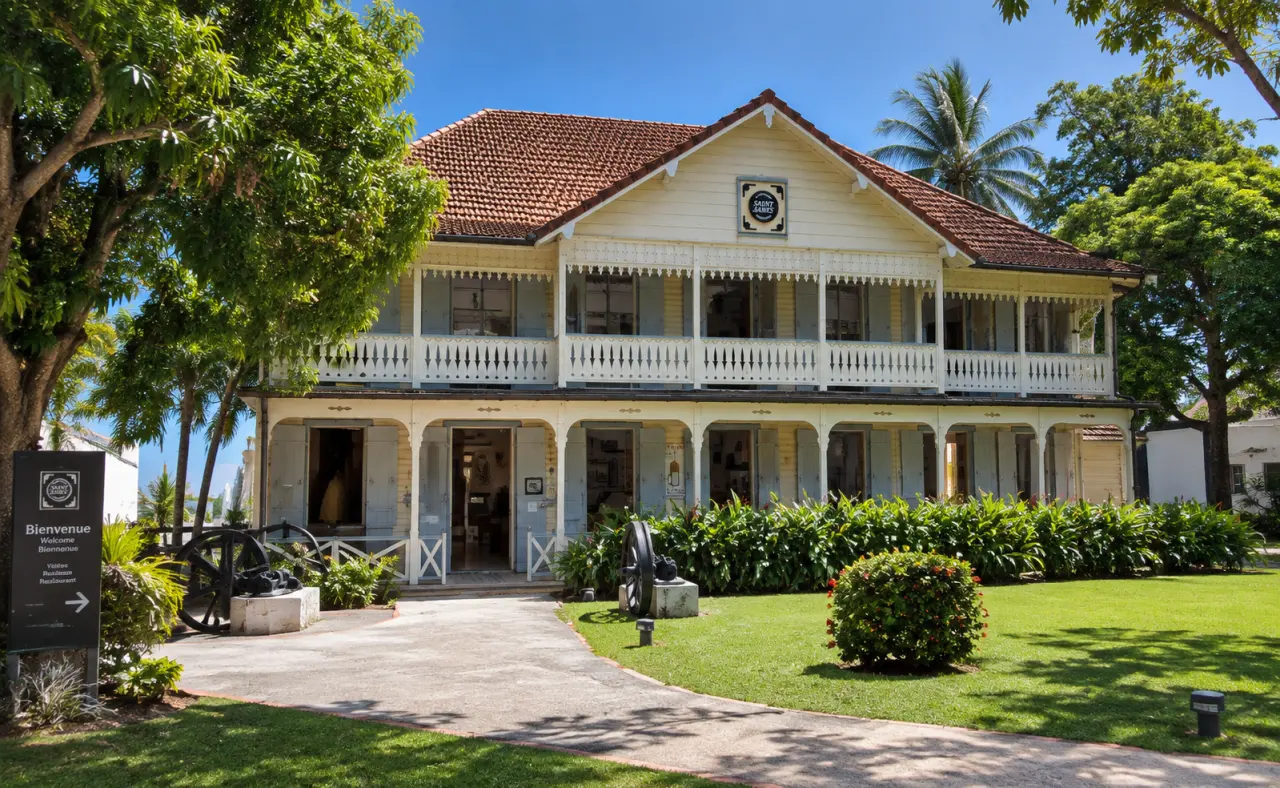 Habitation Saint James à Sainte-Marie en Martinique, maison créole traditionnelle en bois avec galerie ornée, toiture en tuiles et jardin tropical.
