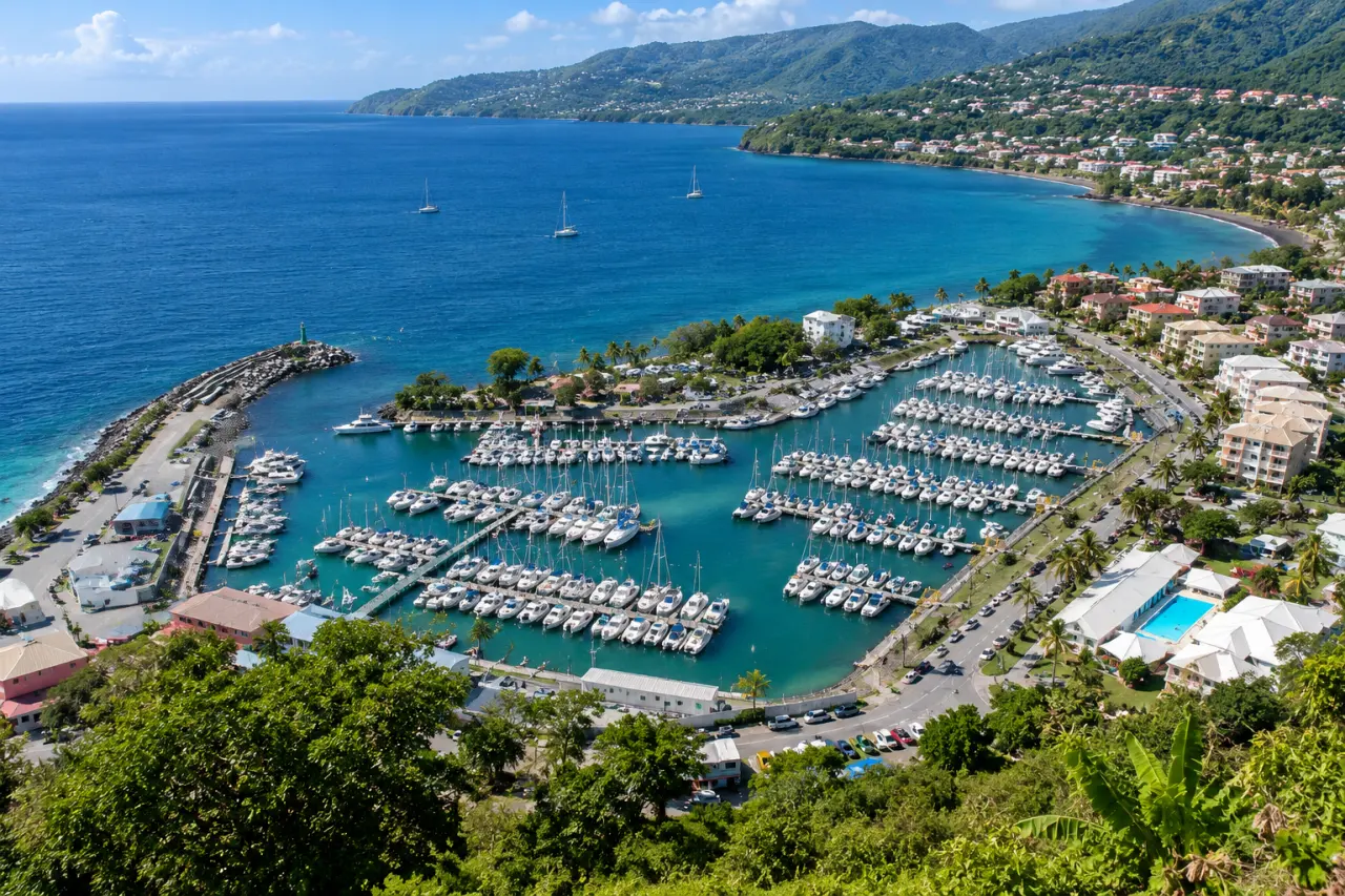 Marina de la Guadeloupe vue du ciel, port de plaisance, bateaux, eaux turquoise et côte tropicale montagneuse.