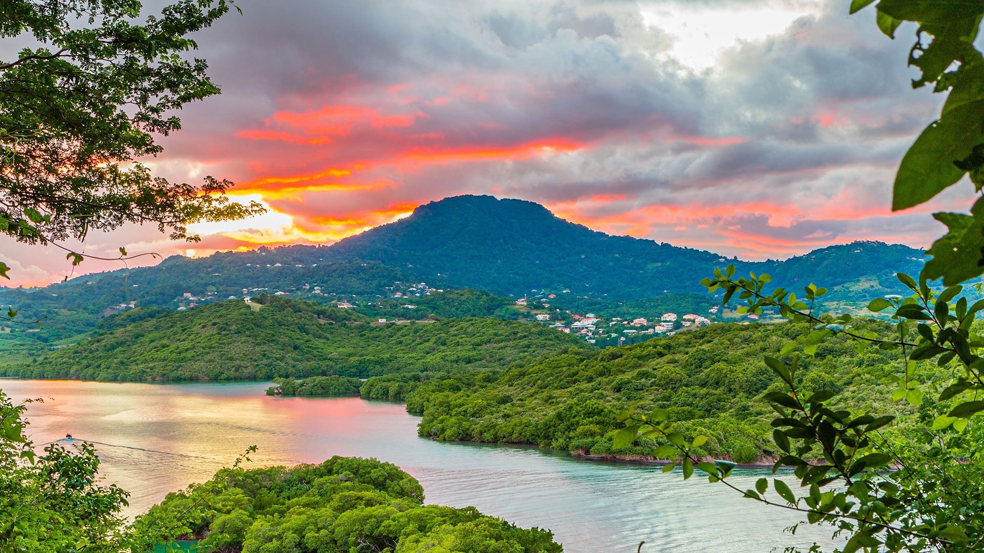 Coucher de soleil flamboyant sur le Trou Cochon au Vauclin en Martinique : bras de mer, mangroves et montagnes au loin.