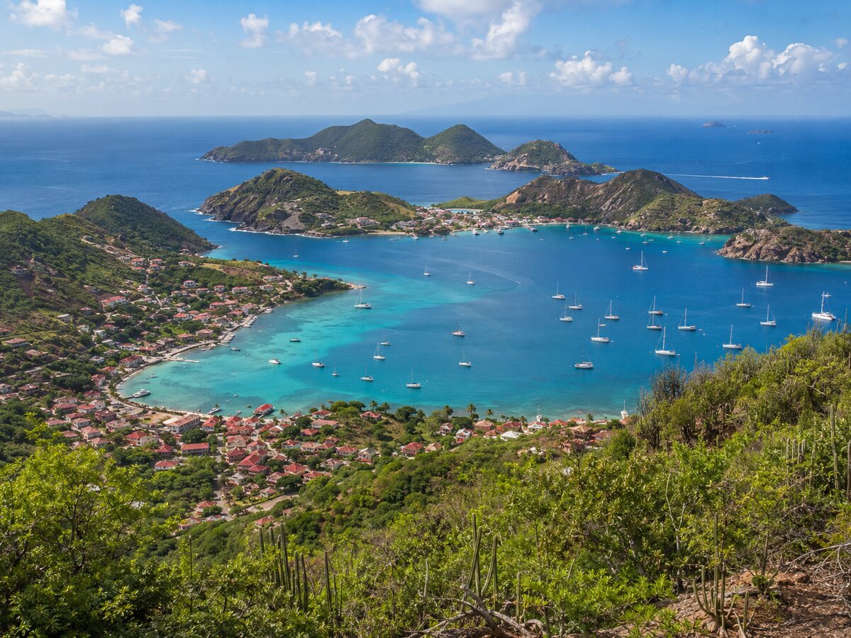 Baie des Saintes avec ses collines et son eau turquoise , on peut y voir des bateaux stationnés dans la baie.