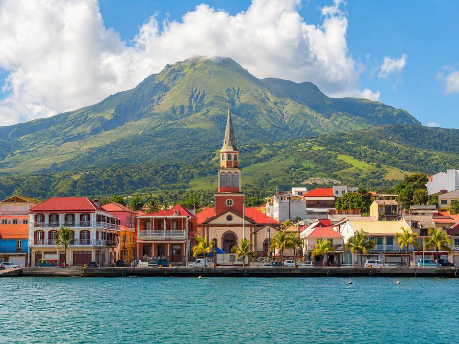 La mer en premier plan , la ville et ses édifices en deuxième plan et la Souffrière et les montagnes voisines de Basse-terre en 3eme plan.