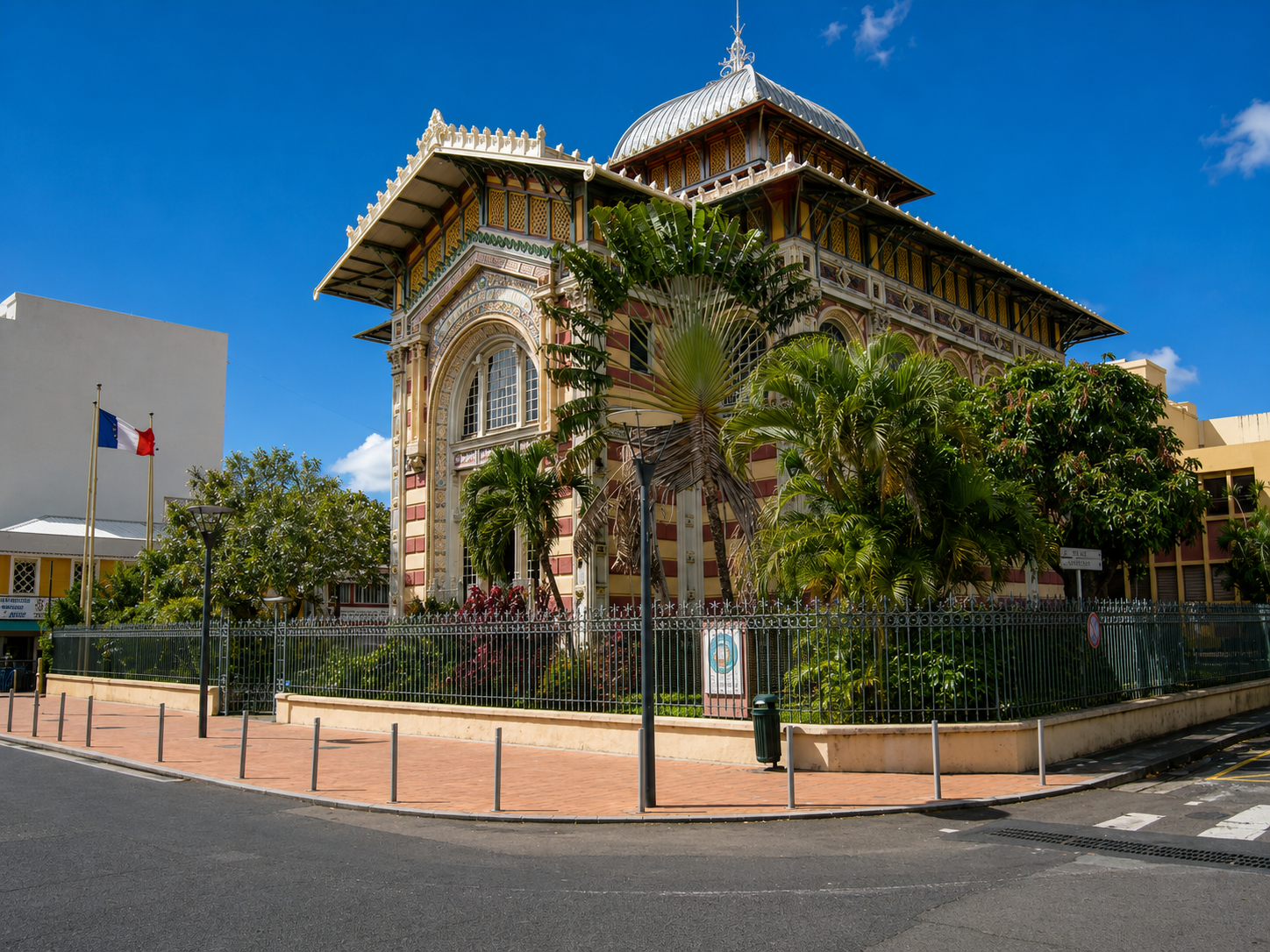 Bibliothèque Schœlcher à Fort-de-France en Martinique : bâtiment historique à l'architecture colorée et jardin clôturé. 