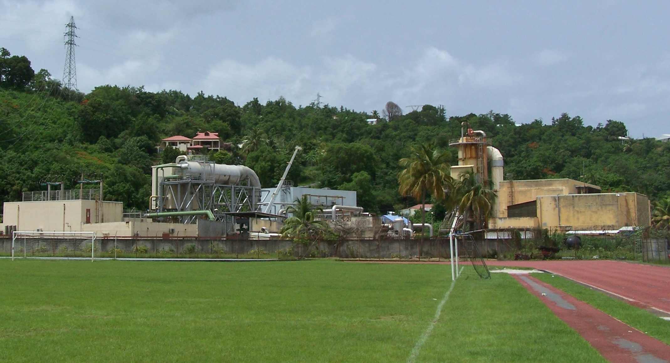 Installations industrielles de la centrale géothermique de Bouillante en Guadeloupe, montrant des cuves métalliques, des cheminées et des conduites techniques