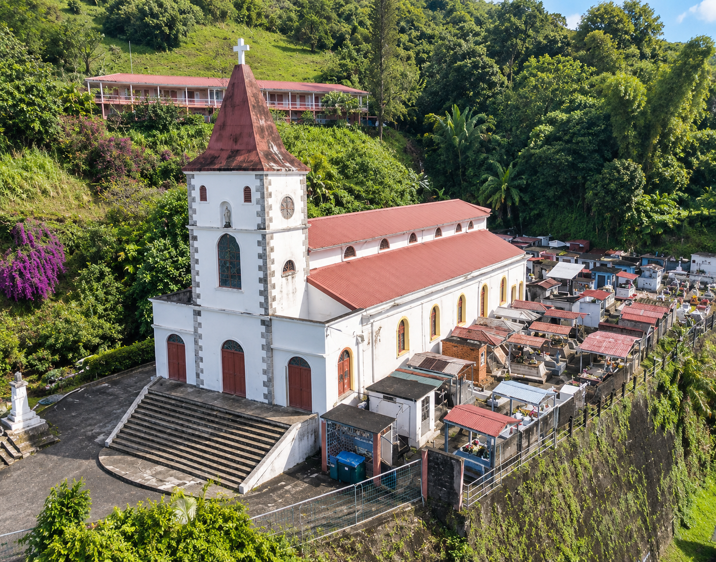 Église de la Martinique entourée d’un cimetière sur les hauteurs, au cœur d’une végétation tropicale luxuriante.