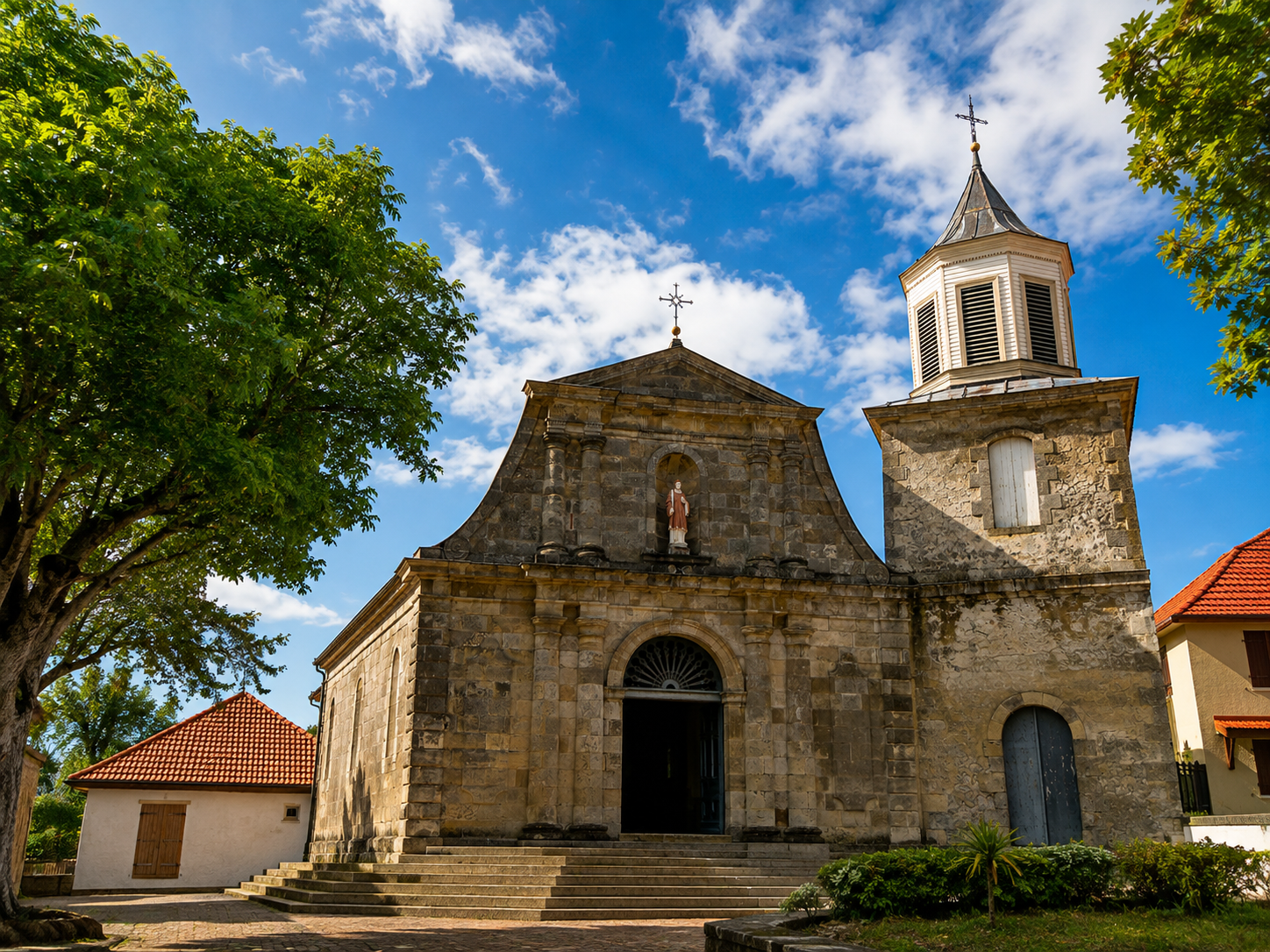 Façade en pierre de l'église Saint-Étienne du Marin en Martinique, avec son clocher sous un ciel bleu.