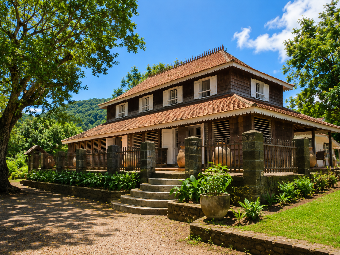 Maison de maître traditionnelle en bois de l'Habitation Clément au François en Martinique entourée d'un jardin.