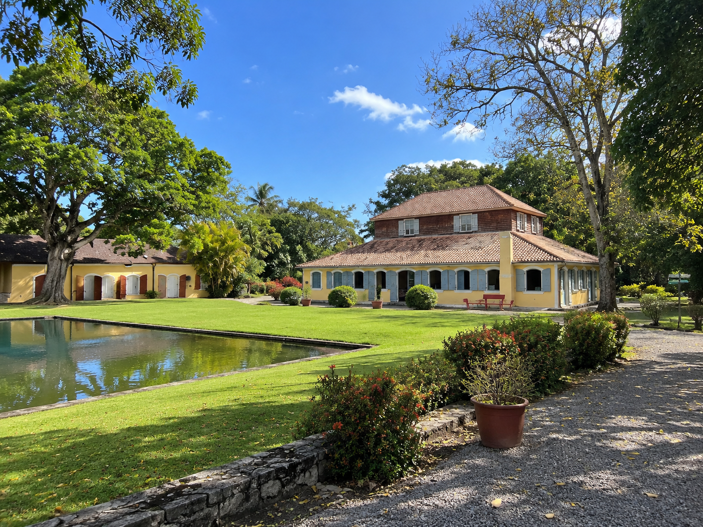 Habitation coloniale en Guadeloupe, maison créole traditionnelle entourée d’un jardin tropical et d’un bassin paysager.
