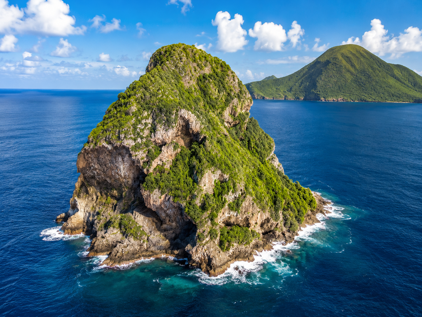 Vue aérienne du Rocher du Diamant recouvert de végétation au milieu de l'océan en Martinique.