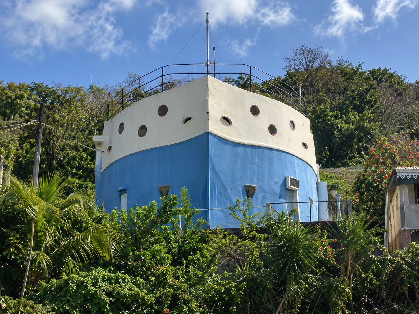 Maison bateau de Basse-Pointe en Martinique, bâtiment original en forme de navire avec coque bleue, hublots et végétation tropicale.
