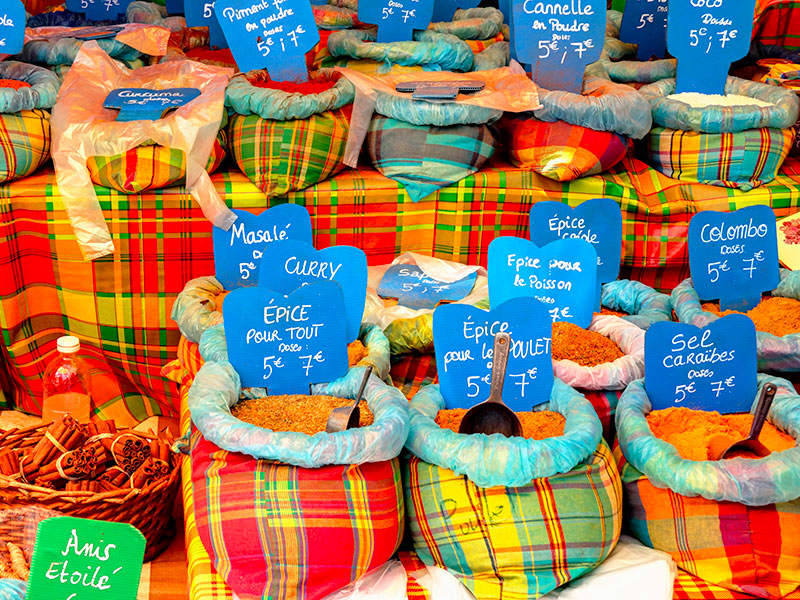Étalage d'épices local au marché créole couvert de Sainte-Anne en Guadeloupe.