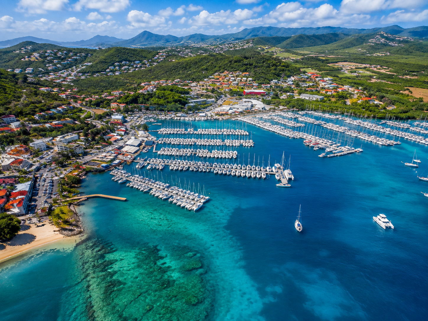 Vue aérienne du port de plaisance du Marin en Martinique, avec ses pontons de bateaux et ses eaux turquoise.